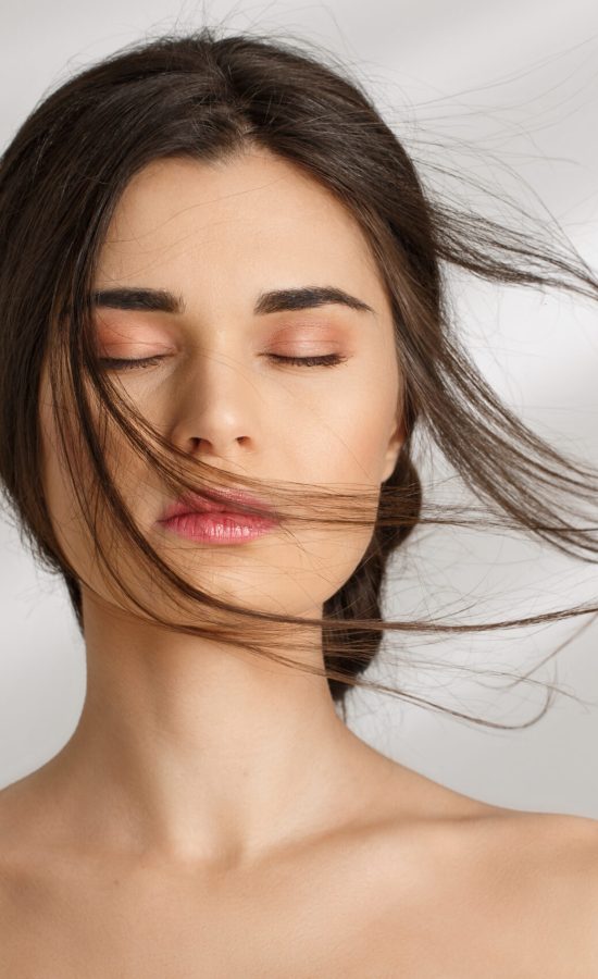 Woman with eyes closed and smooth skin after an aesthetic treatment