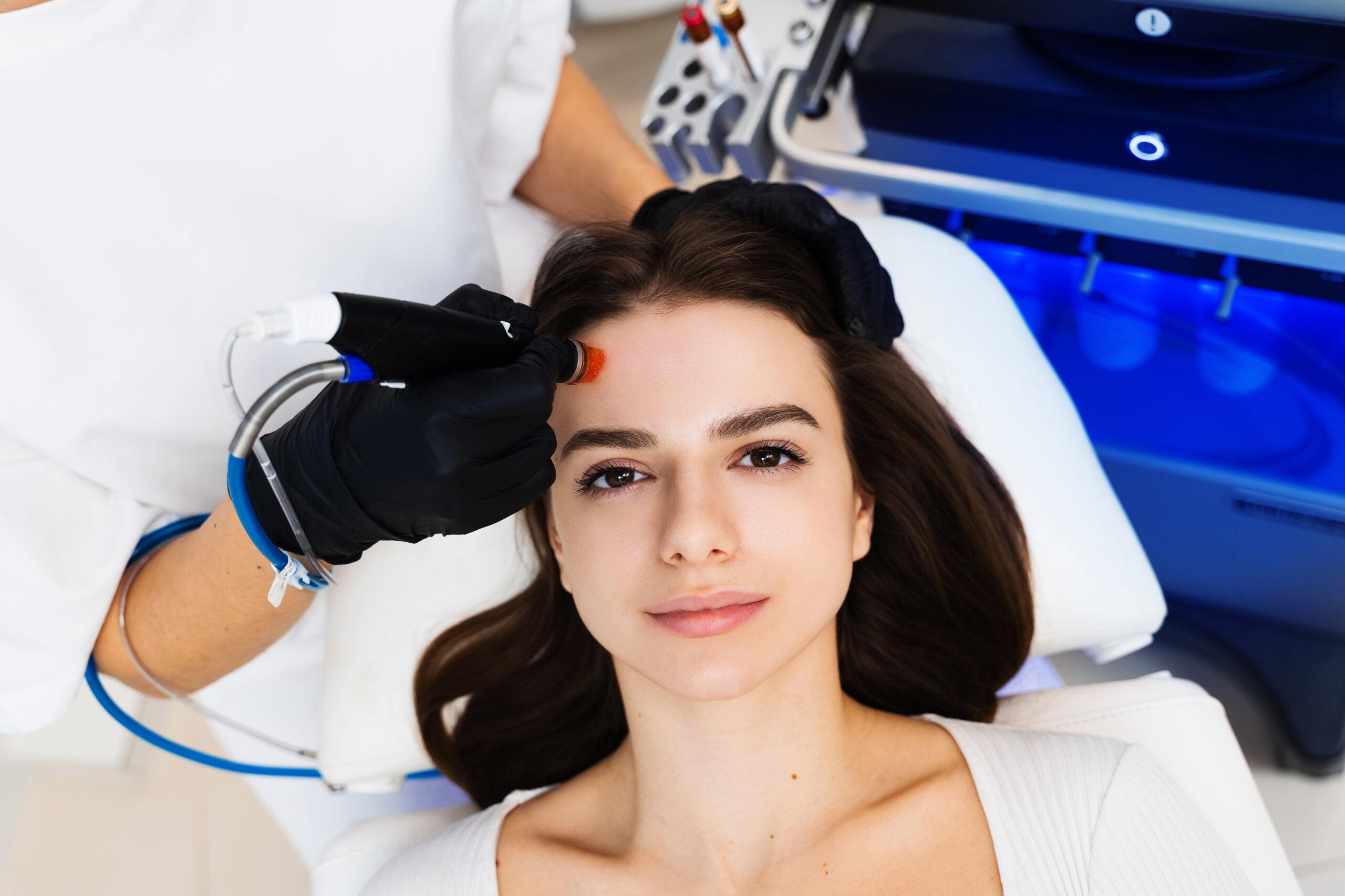 Practitioner performing a HydraFacial treatment on a patient's forehead