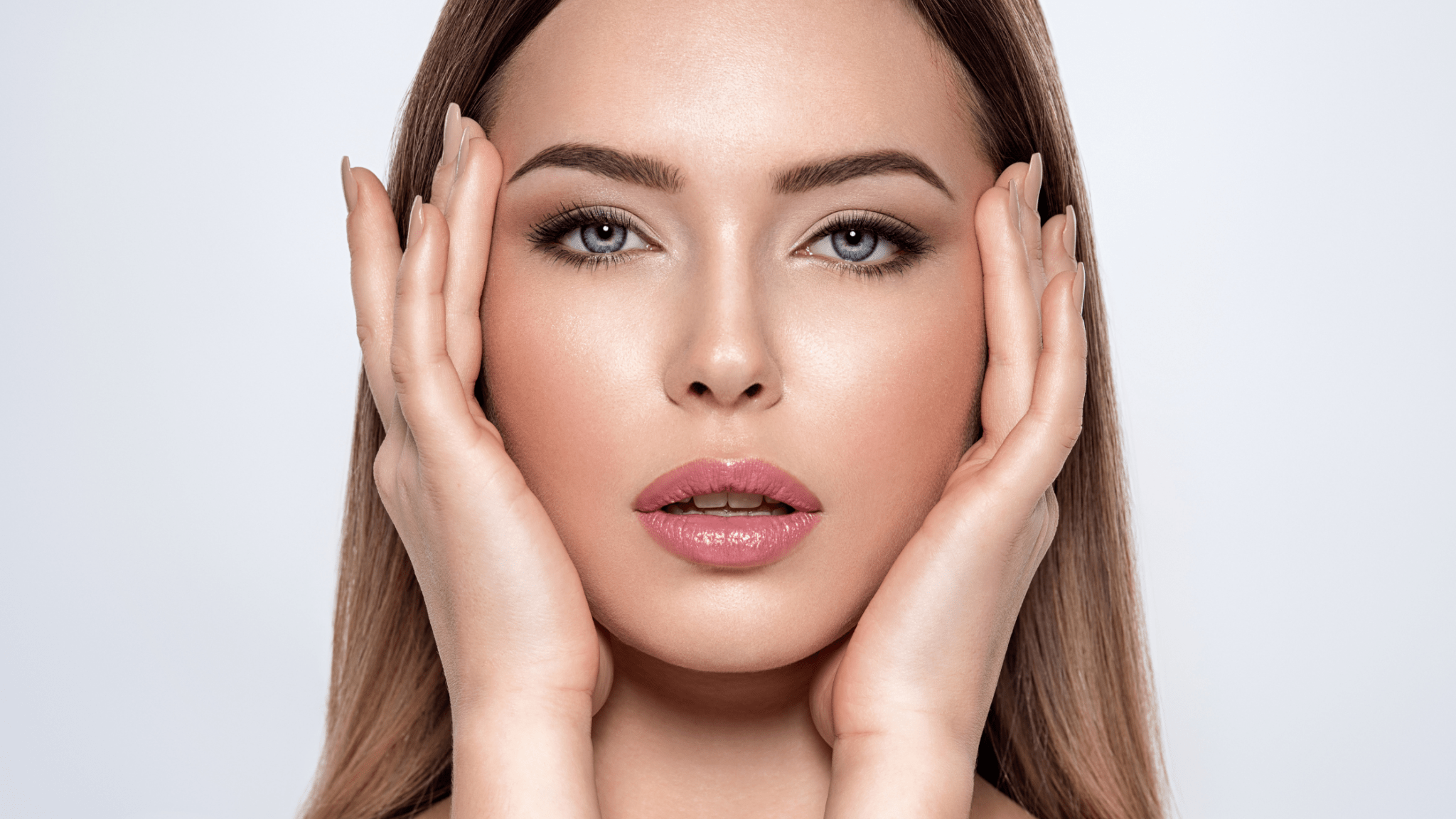 Studio portrait of a woman framing her face with both hands