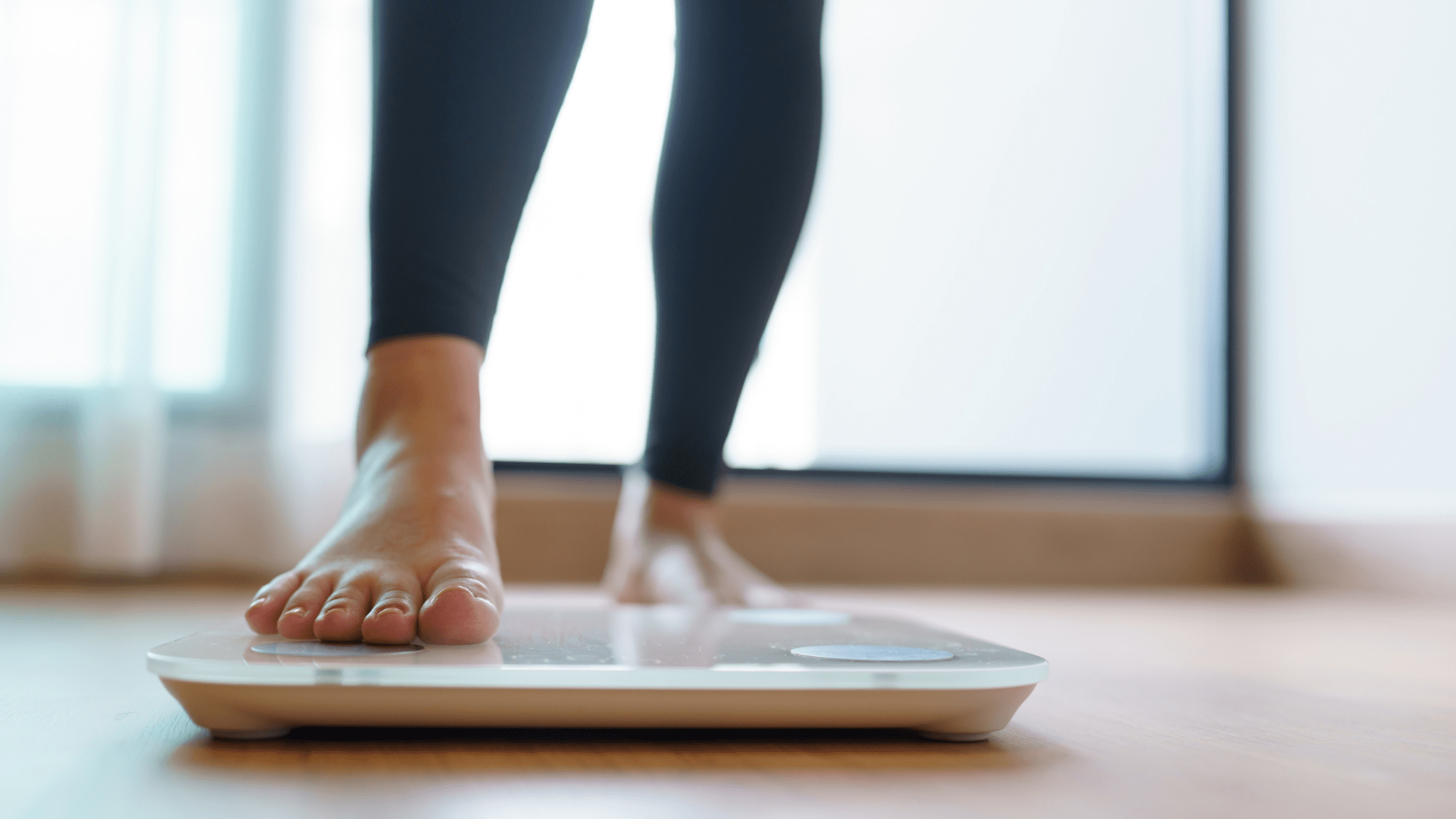 Person stepping onto a body-composition scale